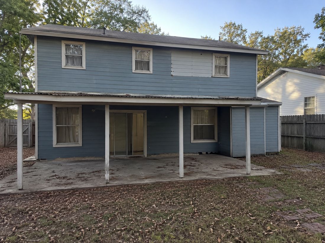 A two-story home with a carport, bought as-is
