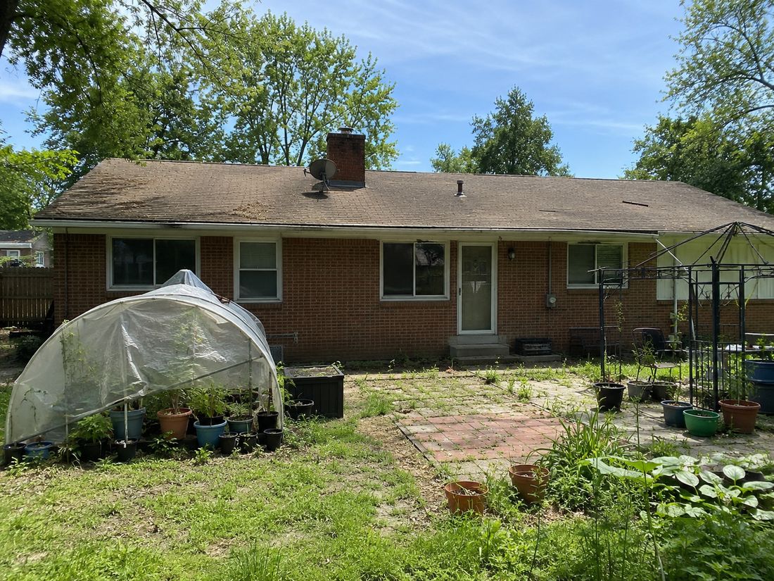 A brick ranch home with a backyard garden