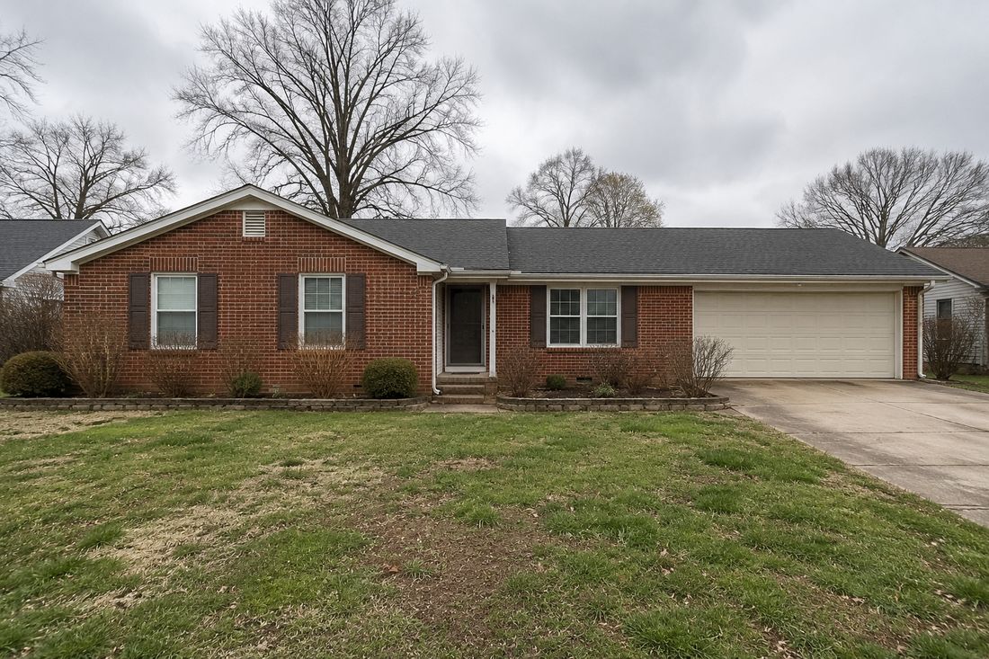 A brick ranch home with a garage on a Kansas City street