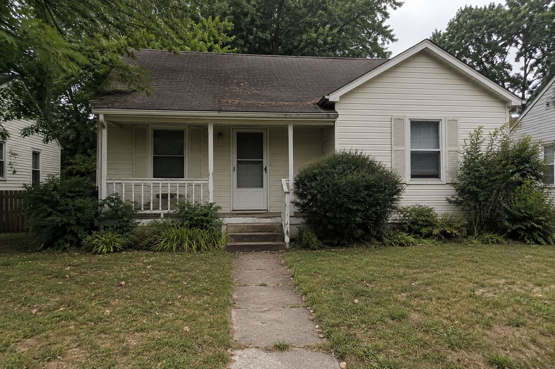 A small white cottage with a front walkway